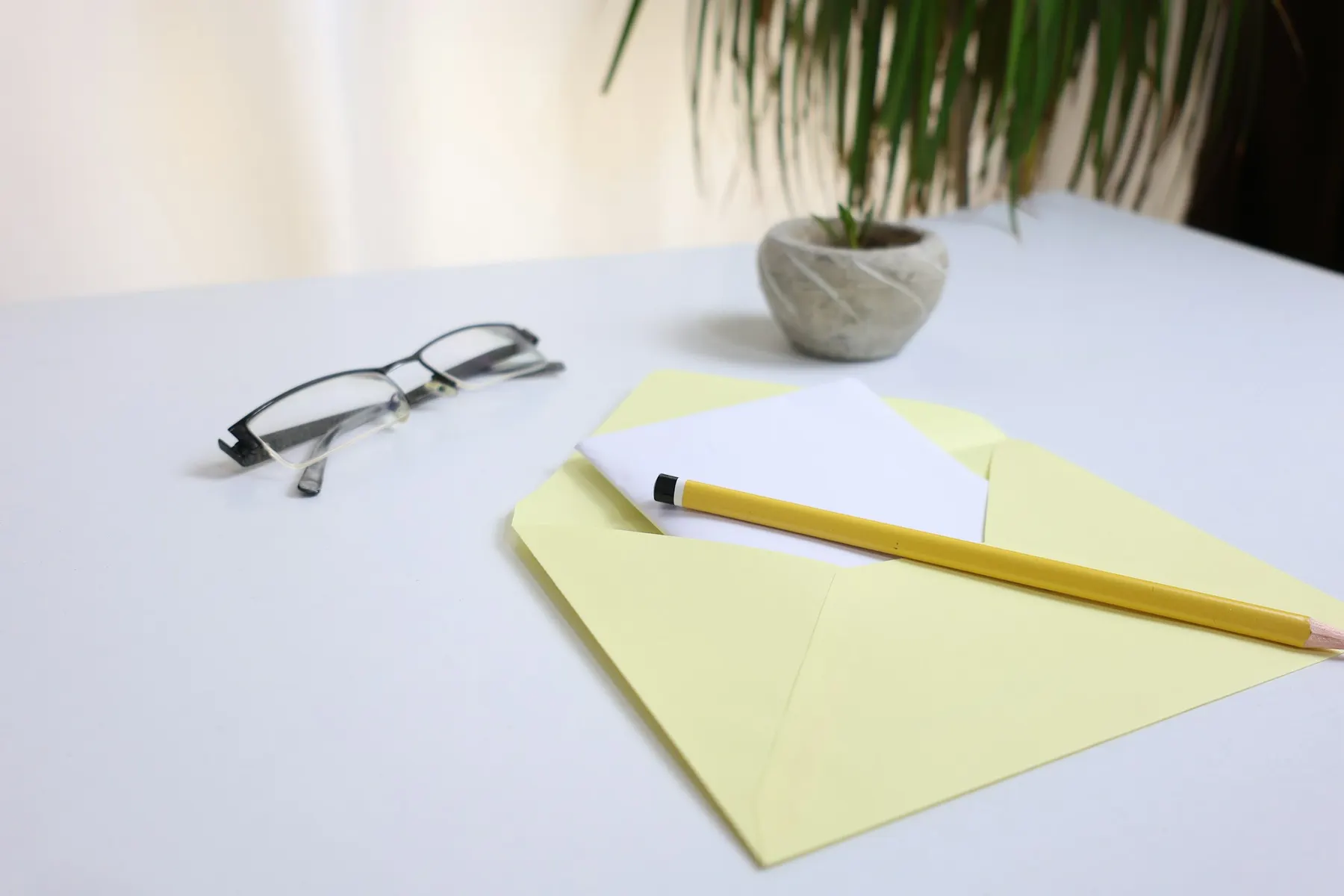 Une enveloppe ouverte, une carte et un crayon sur un bureau clair