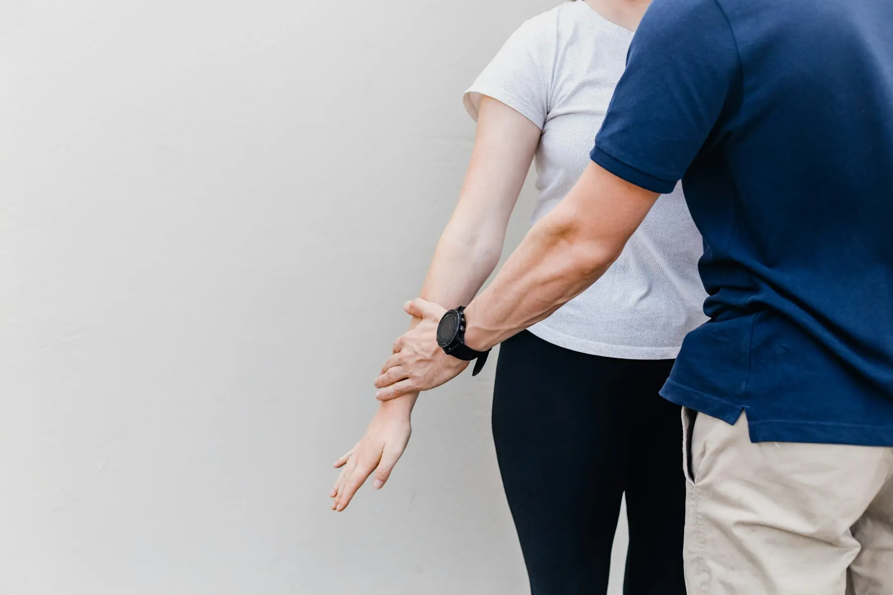 Un kinésithérapeute guide le bras d’une patiente pendant un bilan