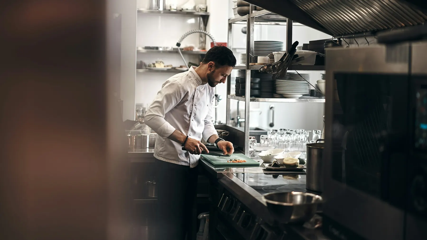Un chef découpe des légumes en cuisine